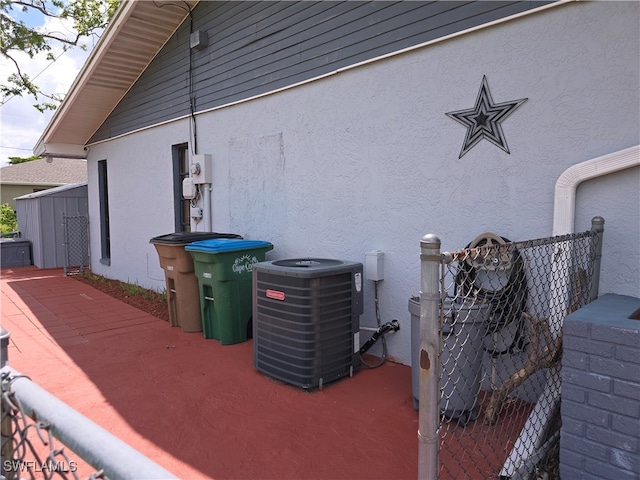 view of side of home with cooling unit and a patio