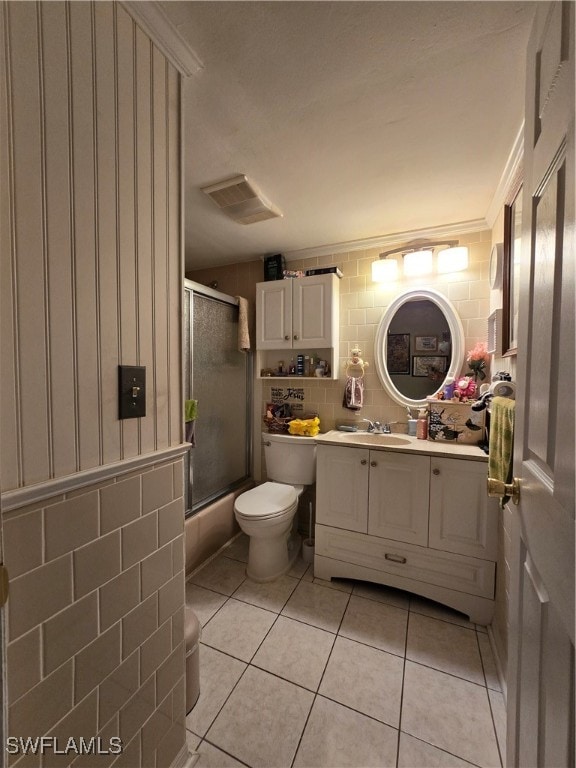 full bathroom featuring shower / bath combination with glass door, vanity, tile patterned floors, tile walls, and toilet