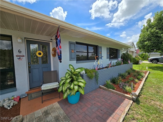 view of exterior entry featuring a yard