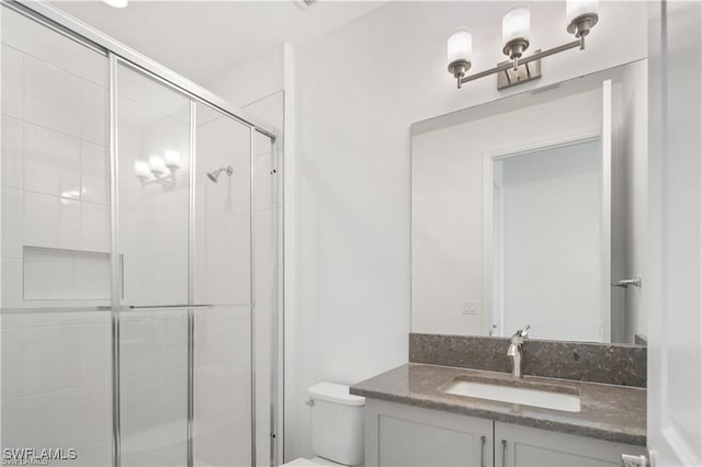 bathroom featuring walk in shower, vanity, and toilet