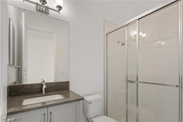 bathroom featuring walk in shower, vanity, and toilet