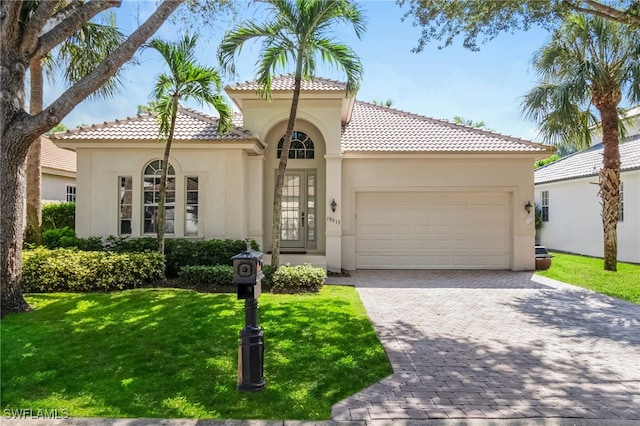 mediterranean / spanish house featuring a front lawn and a garage