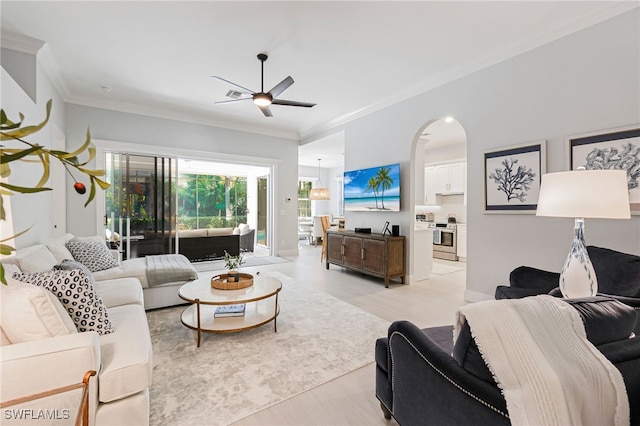 living room with ceiling fan, light hardwood / wood-style flooring, and crown molding