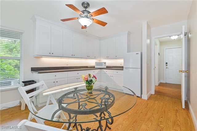 kitchen with white appliances, light hardwood / wood-style flooring, and white cabinetry