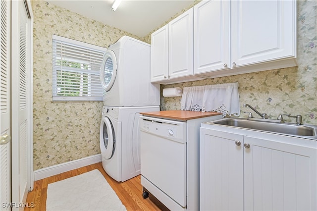 washroom featuring light hardwood / wood-style floors, cabinets, sink, and stacked washer and clothes dryer