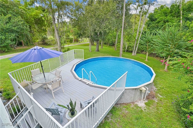 view of pool featuring a yard and a wooden deck