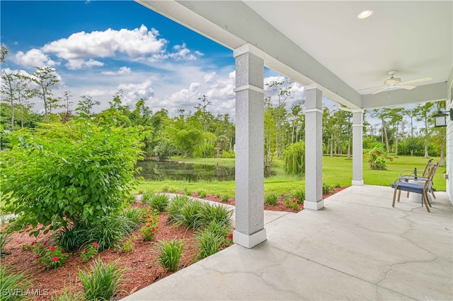 view of patio with ceiling fan and a water view