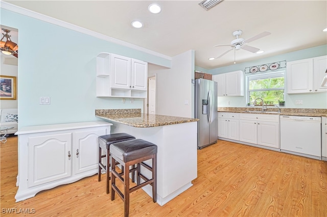 kitchen featuring dishwasher, white cabinets, sink, stainless steel refrigerator with ice dispenser, and light hardwood / wood-style floors