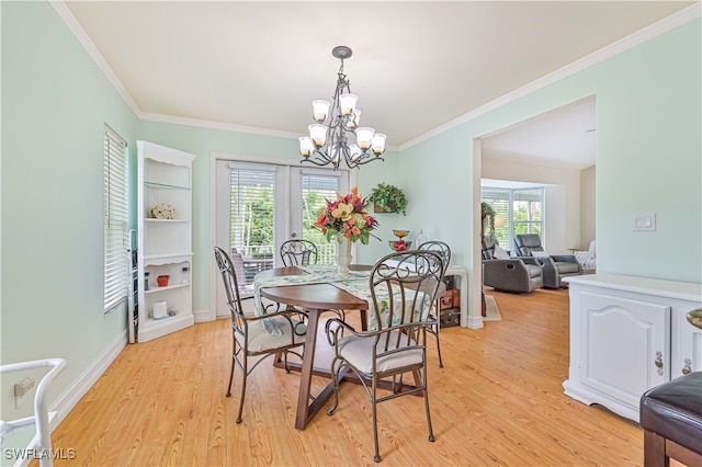 dining room featuring a chandelier, ornamental molding, light hardwood / wood-style flooring, and a healthy amount of sunlight