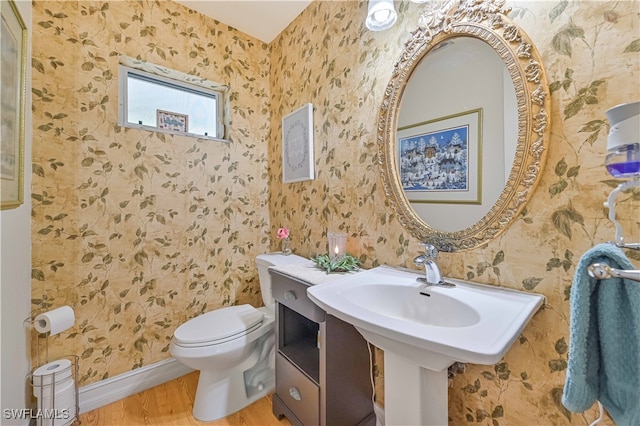 bathroom featuring hardwood / wood-style flooring and toilet