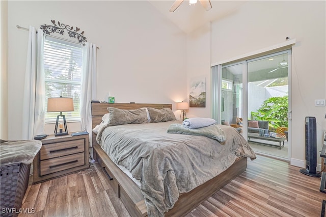 bedroom with ceiling fan, light hardwood / wood-style floors, access to outside, and vaulted ceiling