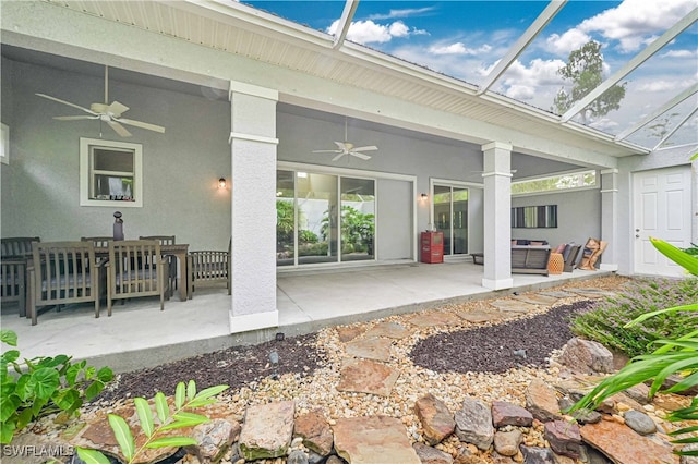 rear view of house featuring outdoor lounge area, glass enclosure, ceiling fan, and a patio area