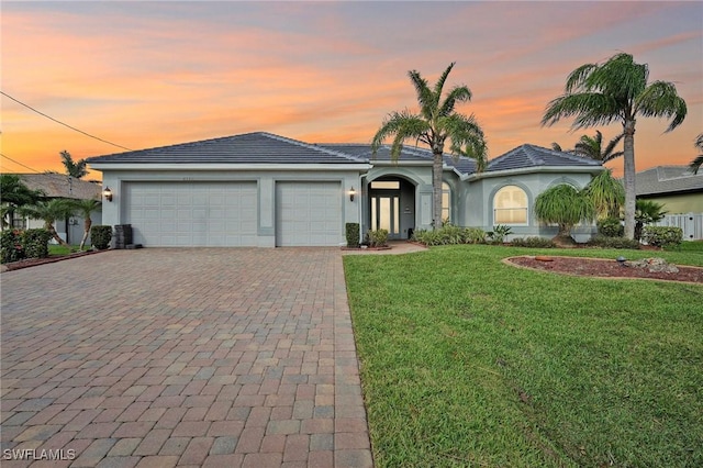 view of front of house with a yard and a garage