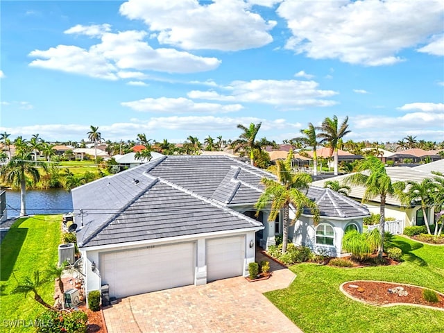 view of front facade featuring a garage, a water view, and a front lawn