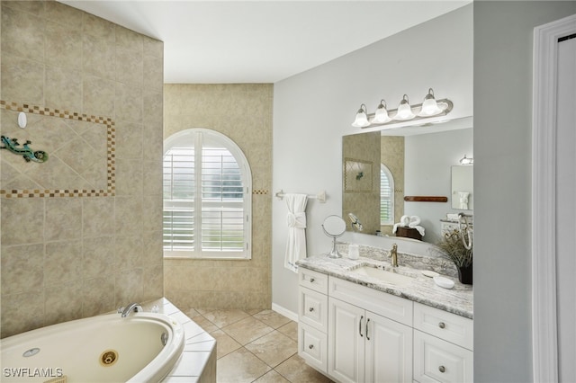 bathroom with tile patterned floors, vanity, and tiled bath