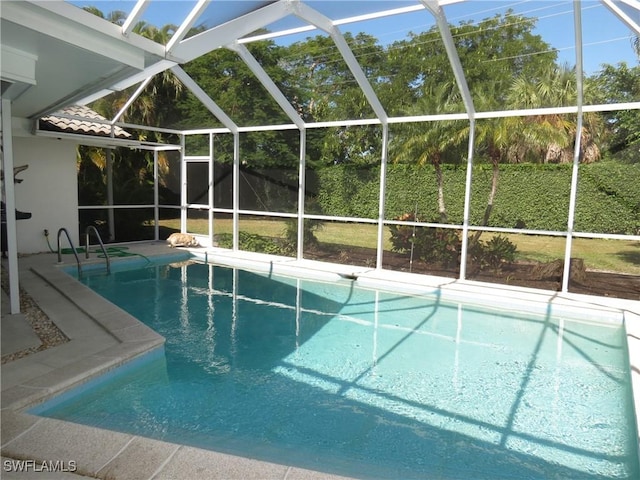 view of swimming pool featuring glass enclosure