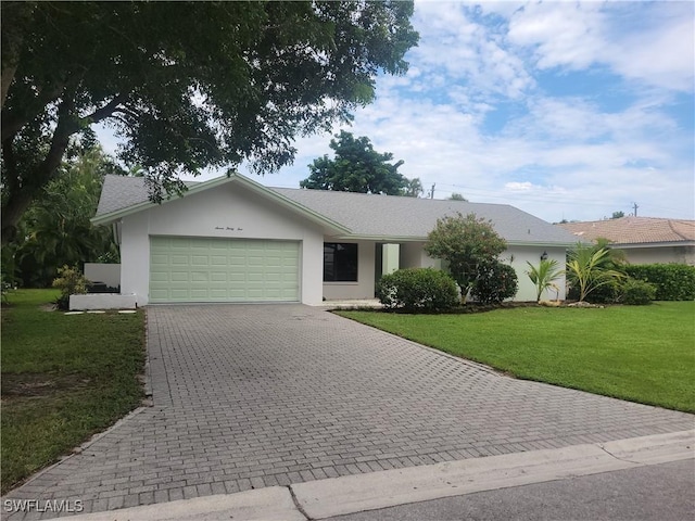 ranch-style home with a garage and a front lawn