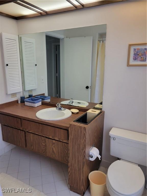 bathroom featuring vanity, tile patterned floors, and toilet