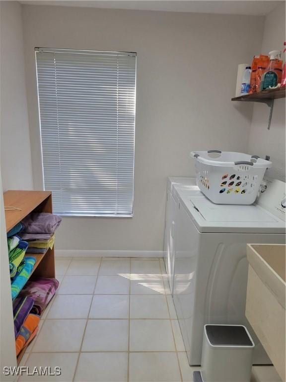 washroom with light tile patterned flooring, separate washer and dryer, and sink