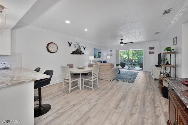 dining room featuring ceiling fan, a textured ceiling, crown molding, and light hardwood / wood-style floors