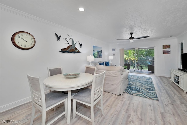 dining area with ceiling fan, a textured ceiling, light wood-type flooring, and crown molding