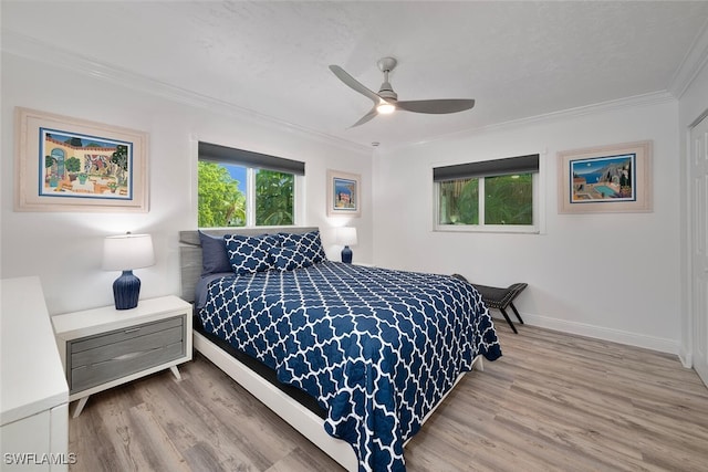 bedroom with crown molding, hardwood / wood-style floors, and ceiling fan