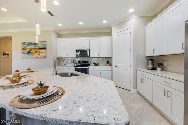 kitchen with white cabinetry, sink, an island with sink, and appliances with stainless steel finishes