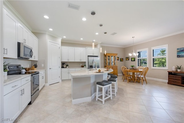 kitchen with white cabinets, stainless steel appliances, and an island with sink