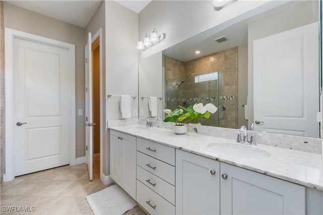 bathroom with tile patterned flooring, walk in shower, and vanity