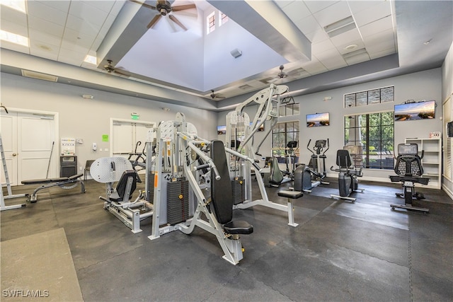 gym featuring a paneled ceiling, a towering ceiling, and ceiling fan