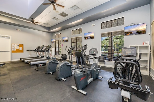 exercise room with ceiling fan and a towering ceiling