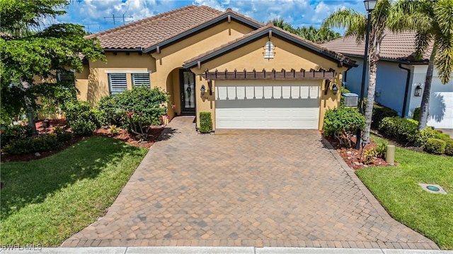 mediterranean / spanish-style home with a garage, a front yard, and cooling unit