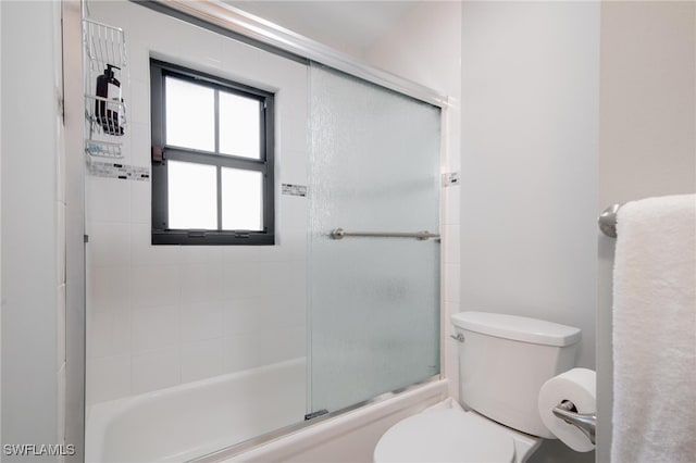 bathroom with combined bath / shower with glass door and toilet