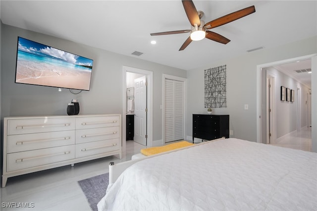 bedroom featuring a closet, ensuite bath, and ceiling fan