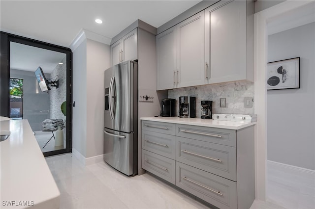 kitchen featuring gray cabinets, stainless steel refrigerator with ice dispenser, and backsplash