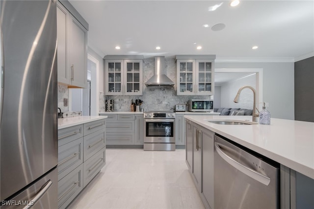 kitchen with tasteful backsplash, sink, stainless steel appliances, wall chimney exhaust hood, and gray cabinets