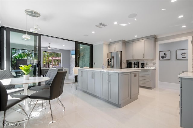 kitchen featuring stainless steel fridge with ice dispenser, decorative light fixtures, gray cabinetry, and backsplash