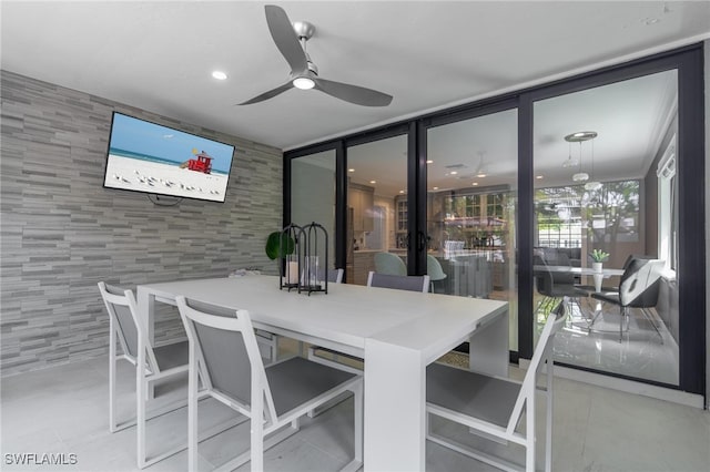 dining space with tile walls and ceiling fan