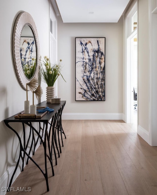 3131 Gin Ln, Naples, FL 34102 - hallway with light wood-style floors and baseboards