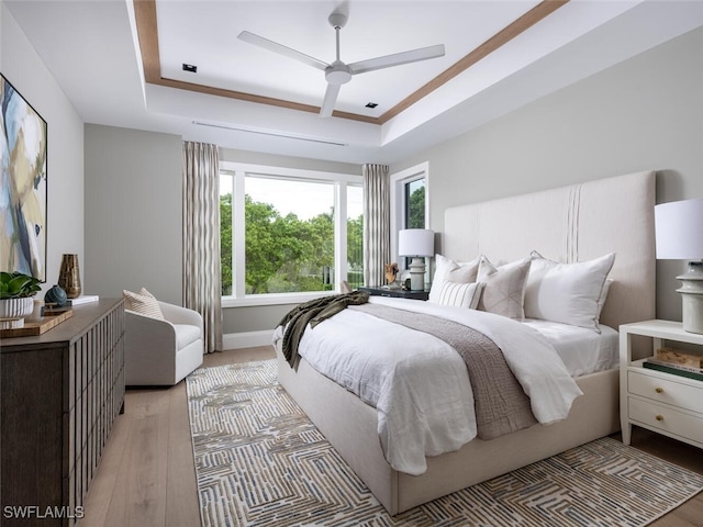 3131 Gin Ln, Naples, FL 34102 - bedroom with a raised ceiling, light wood-style floors, and a ceiling fan