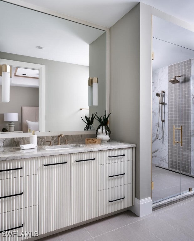 bathroom featuring a shower with door, vanity, and tile patterned flooring