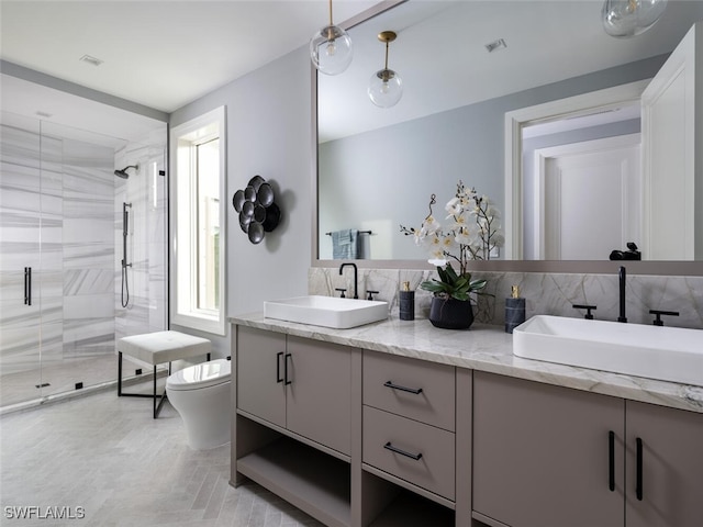 bathroom featuring toilet, a shower with door, vanity, and decorative backsplash