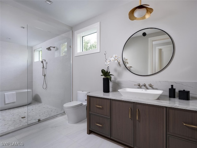 bathroom featuring toilet, tiled shower, and vanity