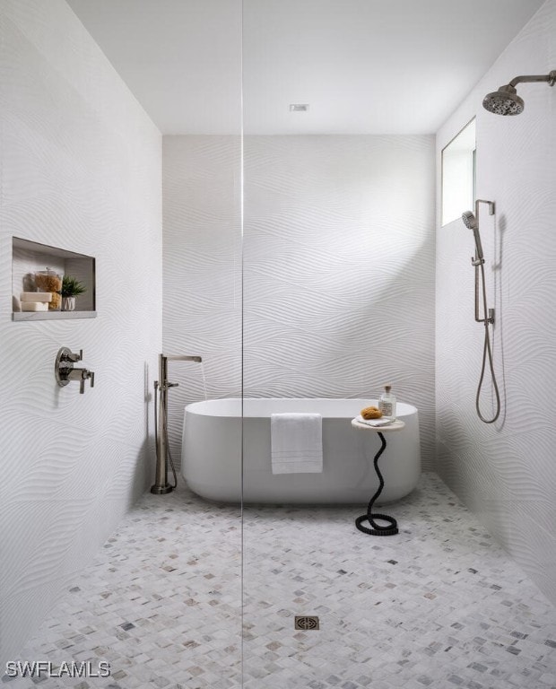 3131 Gin Ln, Naples, FL 34102 - full bathroom featuring tiled shower, a freestanding tub, and tile walls
