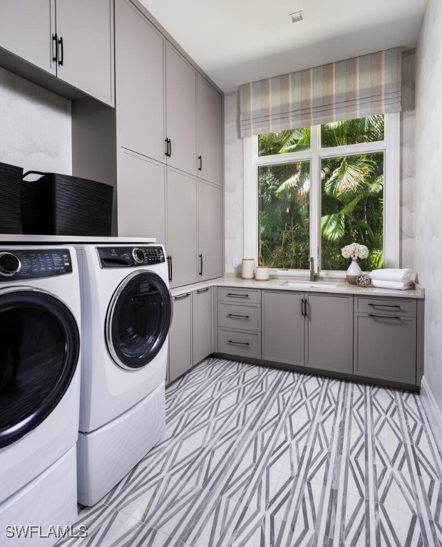 washroom featuring separate washer and dryer, cabinets, and sink