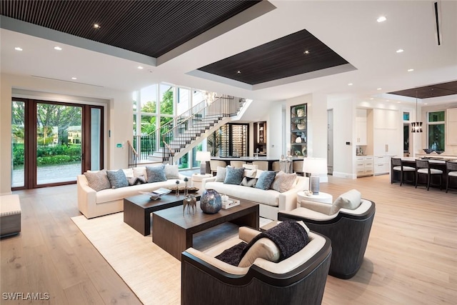 3131 Gin Ln, Naples, FL 34102 - living area with a raised ceiling, stairway, light wood-style floors, and recessed lighting