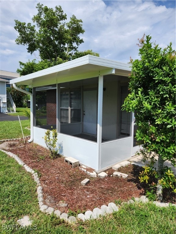 view of property exterior featuring a sunroom