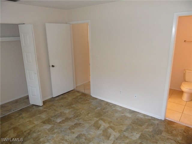 unfurnished bedroom featuring ensuite bath and a closet