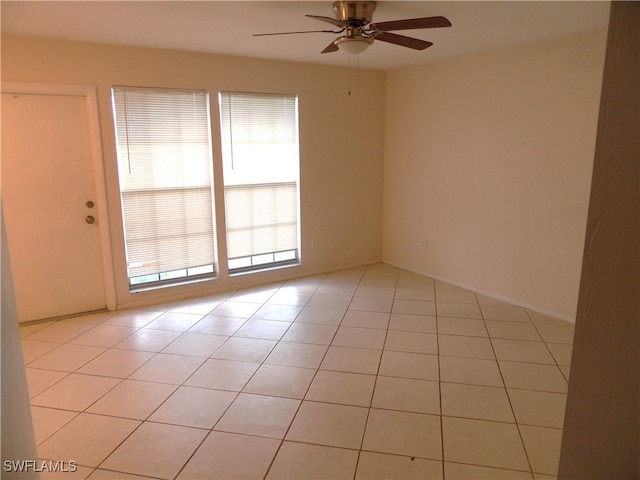 tiled spare room featuring ceiling fan