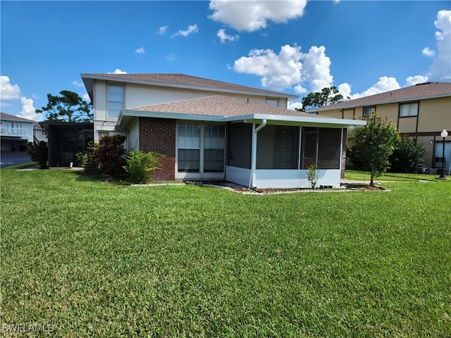 back of property with a sunroom and a yard